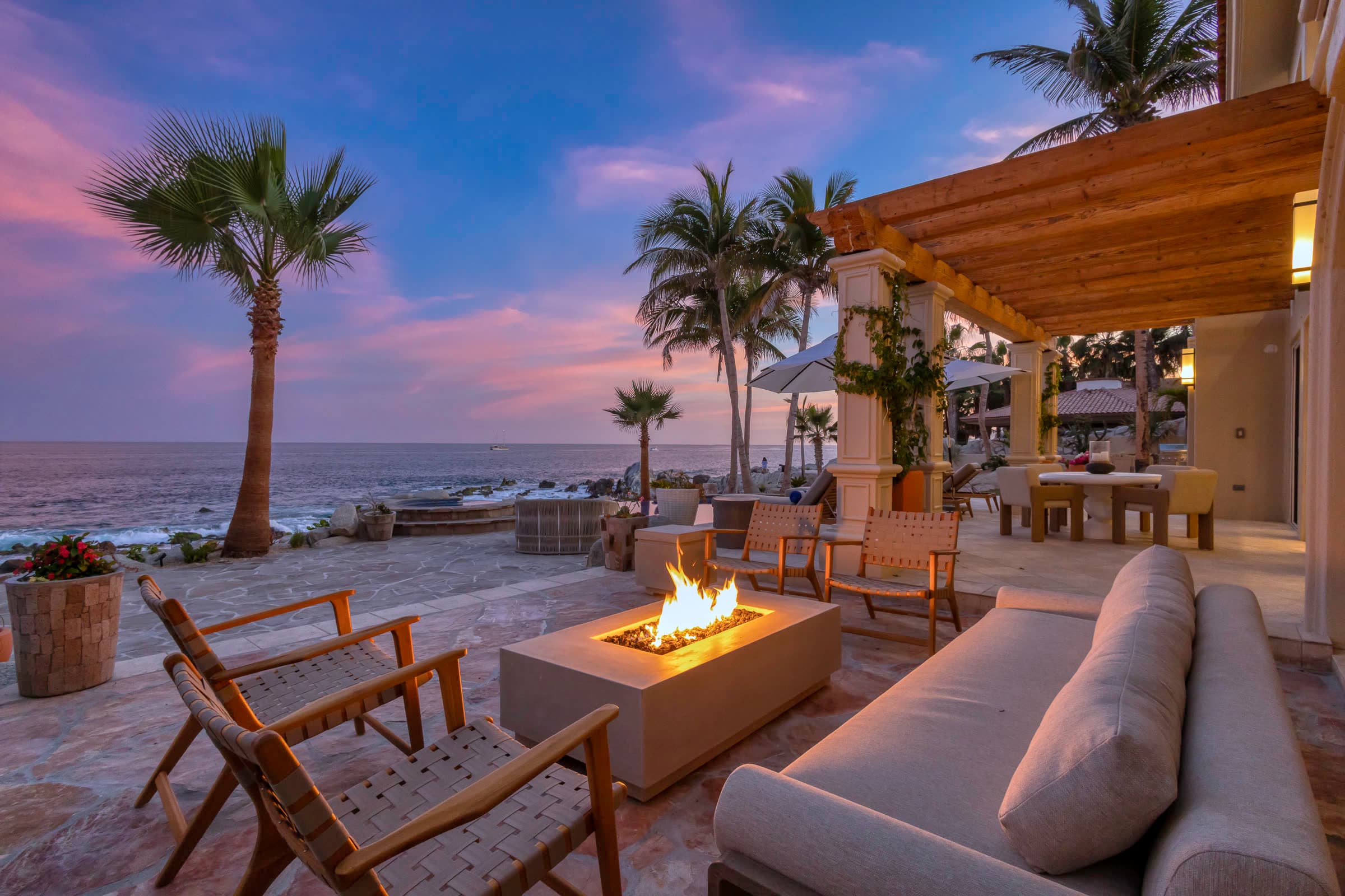 A fire pit on an oceanfront terrace at dusk