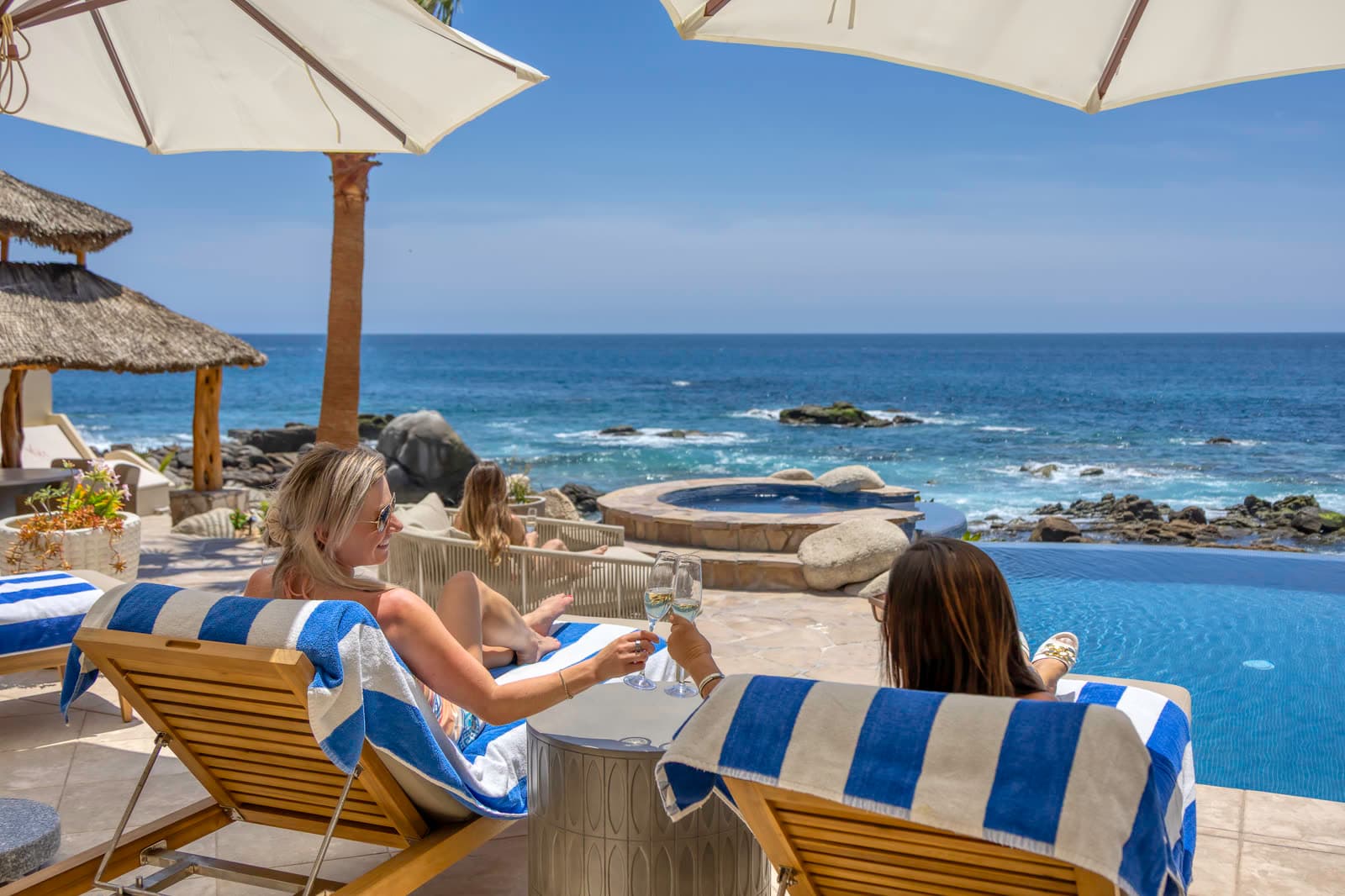Guests relaxing by an infinity pool overlooking the ocean